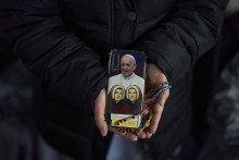 Mníška ukazuje zadný kryt svojho mobilného telefónu s fotografiou pápeža Františka počas večerného modlenia ruženca za jeho zdravie na Námestí sv. Petra vo Vatikáne vo štvrtok 6. marca 2025. FOTO: TASR/AP