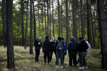 Policajt komunikuje prostredníctvom vysielačky, keď spolu s kolegom sledovali skupinu migrantov, ktorí nelegálne prekročili hranicu z Poľska do Nemecka neďaleko Forstu juhovýchodne od Berlína. FOTO: TASR/AP