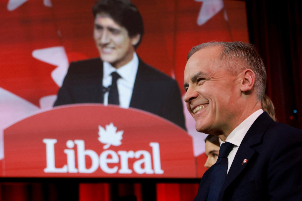 Ekonóm Mark Carney a v pozadí odstupujúci kanadský premiér Justin Trudeau na zjazde vládnej Liberánej strany v Ottawe. FOTO: REUTERS