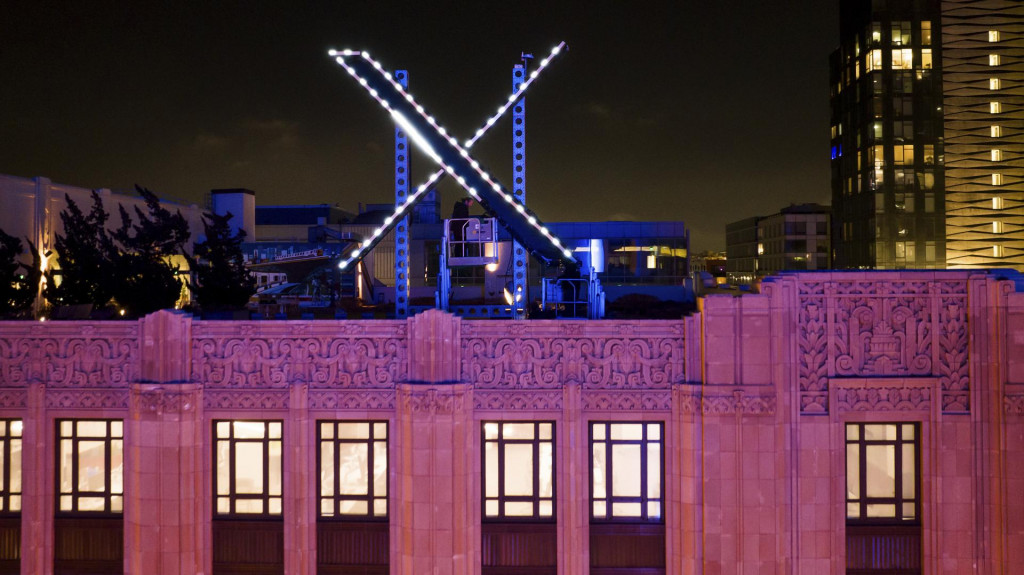 Na archívnej snímke z 28. júla 2023 pracovníci inštalujú logo spoločnosti X umiestnené na streche jej sídla v kalifornskom San Franciscu. FOTO: TASR/AP
