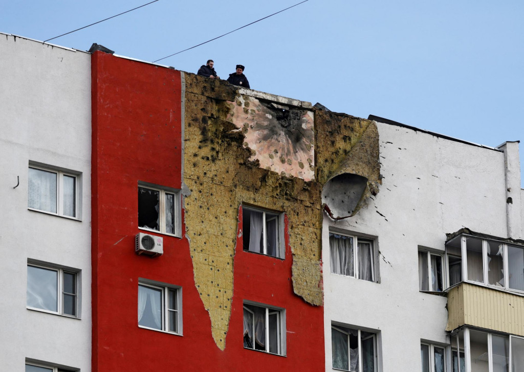 Policajti stoja na streche viacposchodovej obytnej budovy poškodenej pri nedávnom ukrajinskom útoku bezpilotným lietadlom v Moskve. FOTO: Reuters