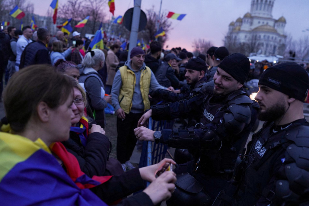 Stúpenci krajne pravicového kandidáta Calina Georgesca sa počas protestu rozprávajú s policajtmi. FOTO: Reuters