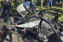 Hasič civilnej obrany hasí auto, ktoré zasiahol izraelský dron v prístavnom meste Sidon na juhu Libanonu. FOTO: TASR/AP