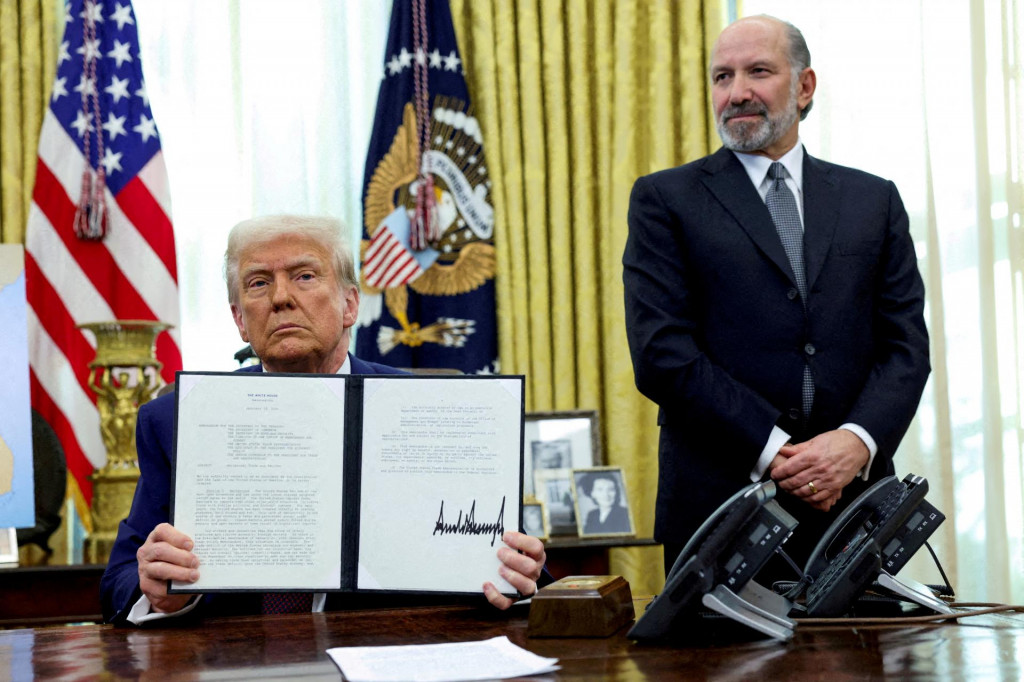 Americký prezident Donald Trump drží v Oválnej pracovni Bieleho domu vo Washingtone, D.C., USA, 13. februára 2025 výkonný príkaz o zvýšení ciel, sprevádzaný ministrom obchodu USA Howardom Lutnickom. FOTO: REUTERS