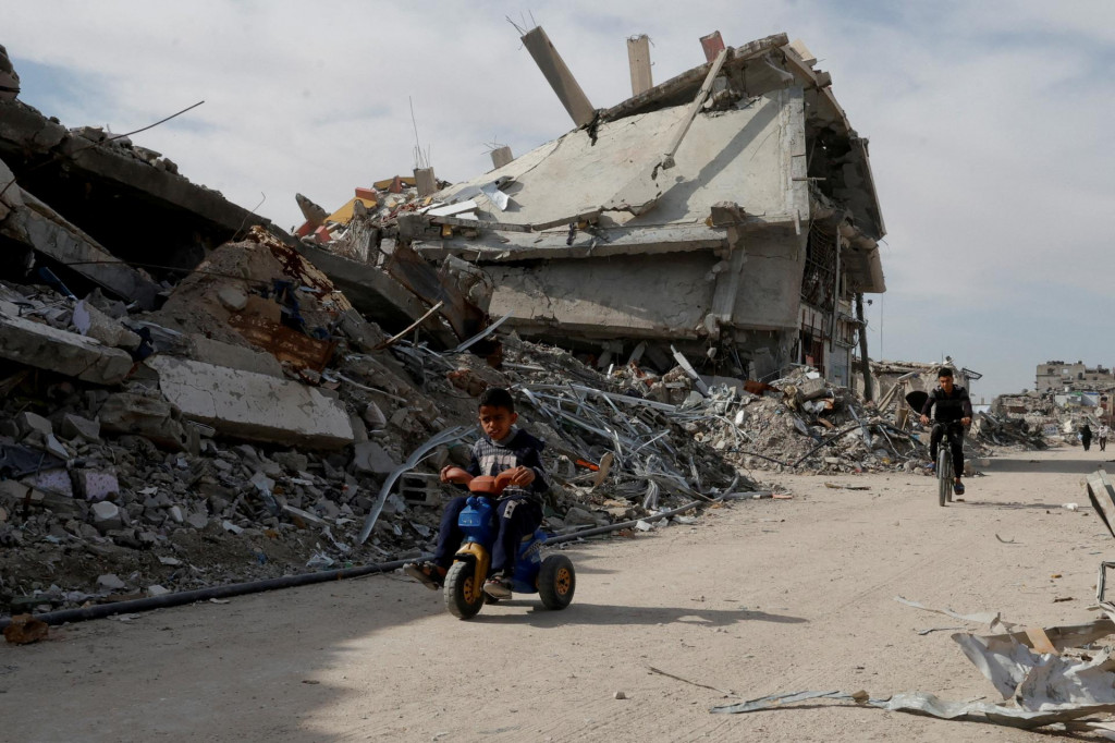Ilustračná fotografia. Palestínske dieťa jazdí na trojkolke pred troskami domov  v Rafahu v južnom Pásme Gazy. FOTO: Reuters