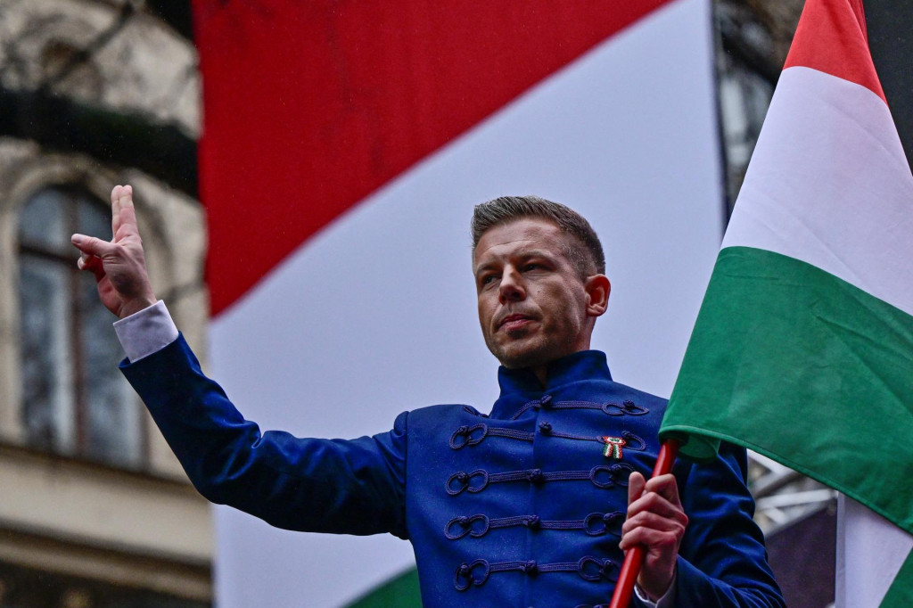 Peter Magyar, líder maďarskej opozičnej strany TISZA, drží štátnu vlajku na demonštrácii počas osláv národného dňa Maďarska. FOTO: Reuters