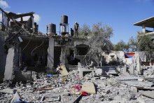 Palestínčania skúmajú svoj zničený dom počas izraelského bombardovania Pásma Gazy, v meste Dajr al-Balah. FOTO: TASR/AP