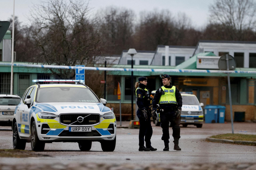 Policajti stoja v blízkosti školy Risbergska vo Švédsko po smrteľnom streleckom útoku. FOTO: Reuters
