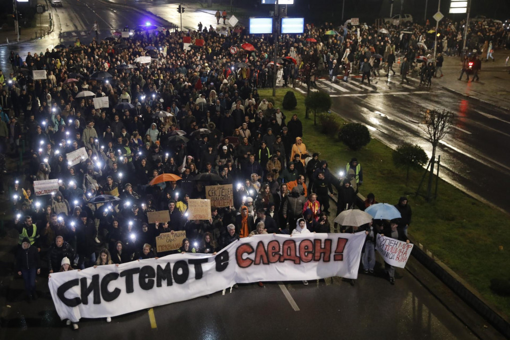 Demonštranti držia transparent s nápisom ”Systém je na rade” počas zhromaždenia v Skopje za obete požiaru nočného klubu v meste Kočani na východe Severného Macedónska. FOTO: TASR/AP