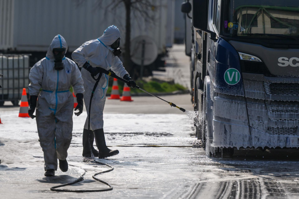 Na snímke rakúsky tím dezinfikuje nákladné vozidlá prichádzajúce na Slovensko z Maďarska na hraničnom priechode Rusovce – Rajka v Bratislave v rámci zavedených prísnych opatrení pre šírenie vysoko nákazlivého ochorenia slintačka a krívačka. FOTO: TASR
