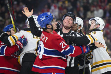 Ľavé krídlo Montrealu Canadiens Juraj Slafkovský a obranca Bostonu Bruins Ian Mitchell v kolízii, uprostred zasahuje rozhodca Jonathan Deschamps. FOTO: TASR/AP