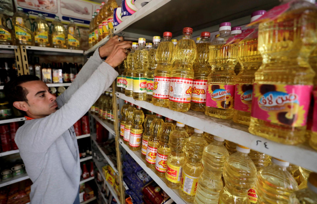 Muž siaha po produktoch na uličke supermarketu s rastlinným olejom v egyptskej Káhire. FOTO: Reuters