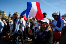 A woman holds a France‘s flag at a rally in support of French far-right leader Marine Le Pen, after calls for a peaceful mobilisation following Marine Le Pen‘s conviction for embezzlement of EU funds, resulting in her being barred from running for office for five years, in Paris, France, April 6, 2025. REUTERS/Gonzalo Fuentes FOTO: Gonzalo Fuentes