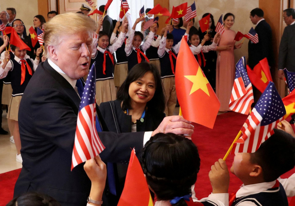 Americký prezident Donald Trump dostáva vietnamskú vlajku, keď ho vítajú študenti v Office of Government Hall v Hanoji, Vietnam, 27. februára 2019. FOTO: REUTERS