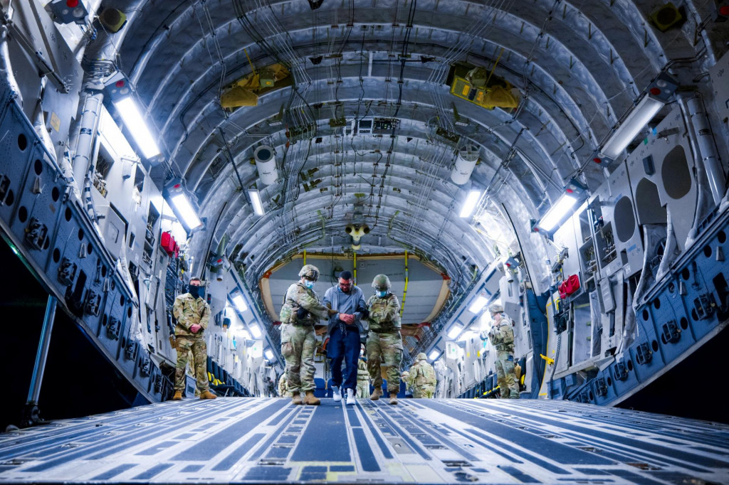 Vojenský personál USA eskortuje údajných členov venezuelského gangu Tren de Aragua a gangu MS-13, ktorých nedávno deportovala vláda USA, aby boli uväznení vo väznici v Salvádore. FOTO: Reuters