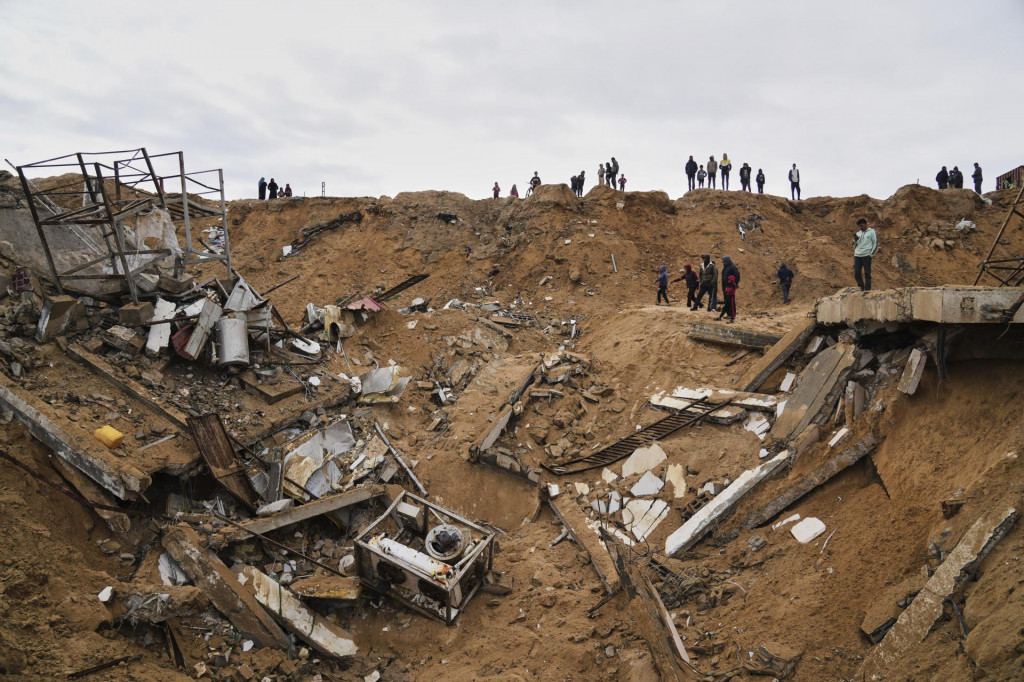 Palestínčania skúmajú trosky zničeného domu počas izraelského bombardovania Pásma Gazy, v meste Dajr al-Balah. FOTO: TASR/AP