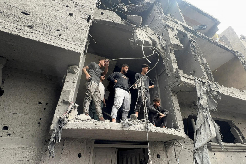 Palestínčania stoja na mieste izraelského útoku na dom v Shejaia v meste Gaza. FOTO: Reuters