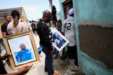 Ľudia držia fotografie bývalého hráča MLB Tonyho Blanca po páde strechy nočného klubu. FOTO: Reuters