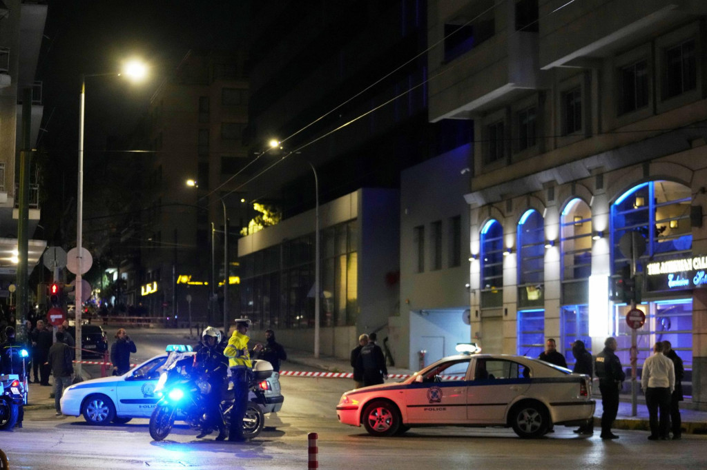 Policajti hliadkujú pred aténskou kanceláriou spoločnosti Hellenic Train (tretia budova vpravo), hlavnej železničnej spoločnosti v Grécku, po výbuchu bomby. FOTO: TASR/AP