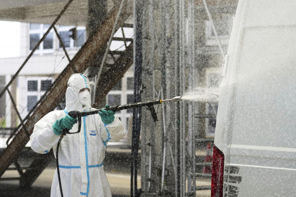 Hasič v špeciálnom ochrannom odeve strieka dezinfekčný prípravok na kamión, aby sa zabránilo šíreniu vysoko infekčnej slintačky a krívačky. FOTO TASR/AP