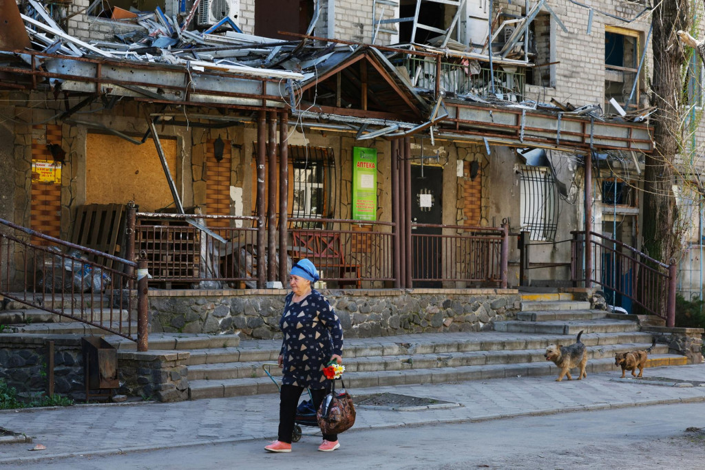 Miestny obyvateľ prechádza popri poškodenej budove v Avdijivke. FOTO: Reuters