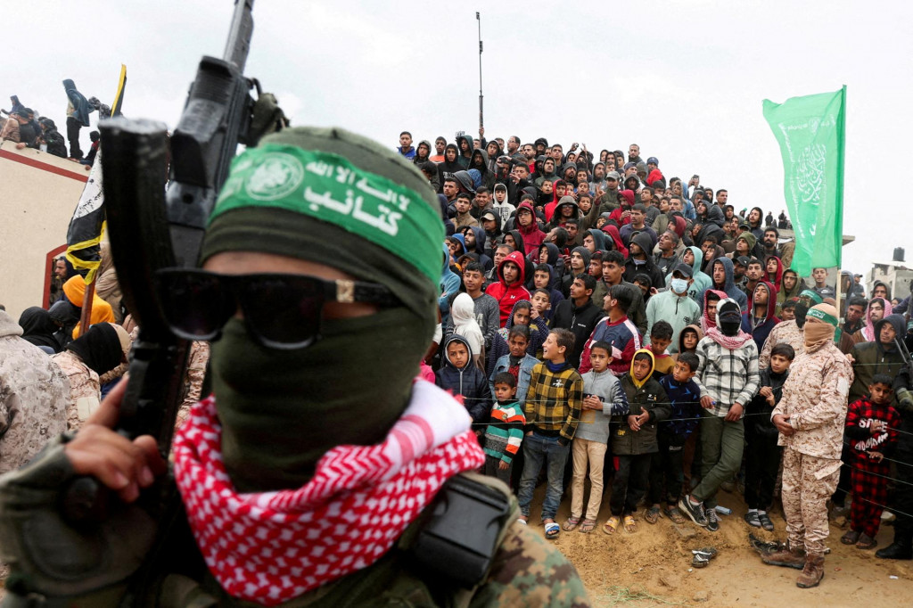 Palestínčania sa pozerajú na to, ako Hamas odovzdal zosnulých rukojemníkov v Chán Júnise v Pásme Gazy. FOTO: Reuters
