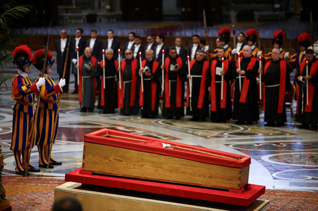 Príslušníci Švajčiarskej gardy stoja pri rakve s telom pápeža Františka. FOTO: Reuters