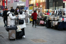 Čínski turisti stoja vedľa pouličných predajcov v nákupnej štvrti Myeongdong v Soule v Južnej Kórei. FOTO: Reuters