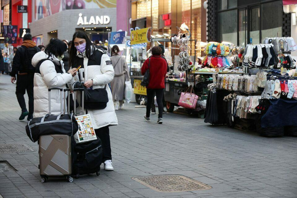 Čínski turisti stoja vedľa pouličných predajcov v nákupnej štvrti Myeongdong v Soule v Južnej Kórei. FOTO: Reuters