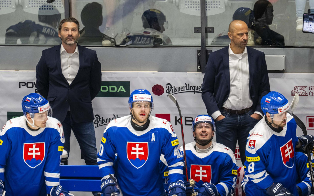 Hlavný tréner hokejovej reprezentácie Slovenska Vladimír Országh (v pozadá vľavo), jeho asistent Ján Pardavý (v pozadí vpravo), ich zverenci Matej Kašlík (vľavo), Miloš Roman (druhý zľava) a Maxim Čajkovič (vpravo) sledujú zo striedačky prípravný zápas Česká republika - Slovensko v Ostrave. FOTO: TASR/Jakub Kotian