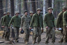 Mladí nováčikovia 28. samostatnej mechanizovanej brigády Rytierov zimného ťaženia Ozbrojených síl Ukrajiny idú do jedálne počas prestávky v cvičení uprostred ruského útoku na Ukrajinu v Kyjevskej oblasti. FOTO: Reuters