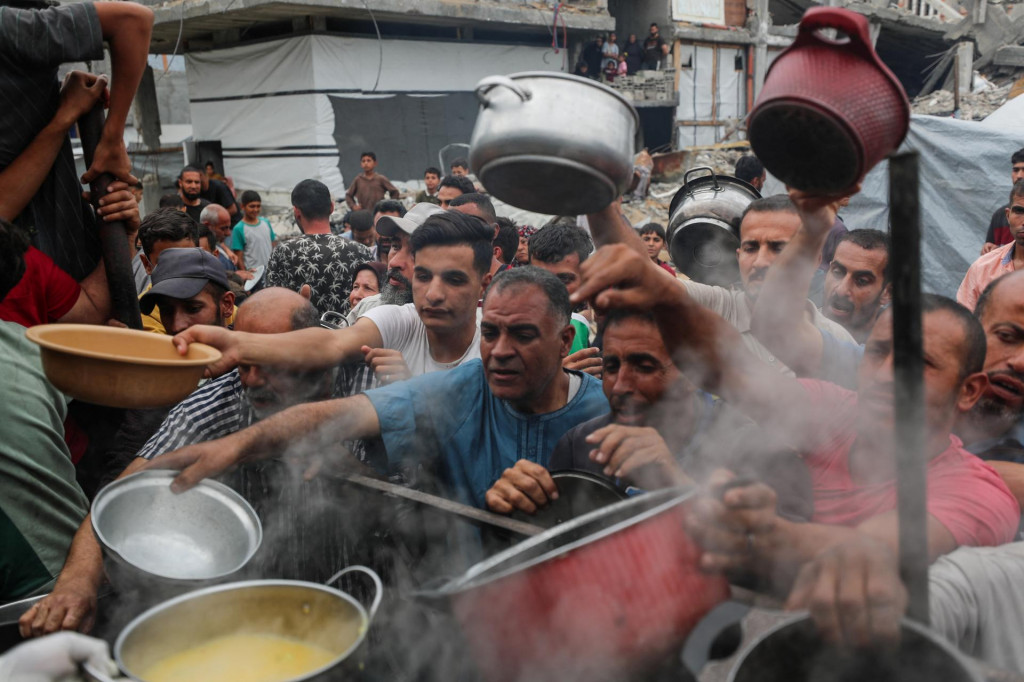 Palestínčania čakajú na jedlo pripravené charitatívnou kuchyňou v Beit Lahia v severnom pásme Gazy 24. apríla 2025. FOTO: REUTERS