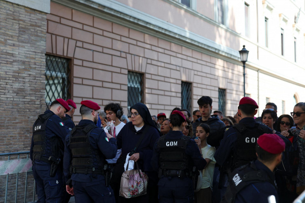 Príslušníci polície prehľadávajú ľudí čakajúcich na vstup do Baziliky svätého Petra, aby vzdali úctu pápežovi Františkovi v Ríme. FOTO: Reuters