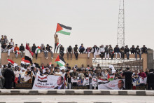 Egypťania mávajú palestínskymi a egyptskými zástavami pri vítaní konvoja vozidiel s egyptským prezidentom Abdalom Fattáhom Sísím a francúzskym prezidentom Emmanuelom Macronom počas ich návštevy v meste Ariš. FOTO: TASR/AP