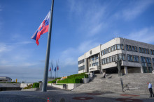 Na snímke štátna vlajka Slovenskej republiky (v popredí) je spustená na pol žrde v súvislosti s úmrtím pápeža Františka pred budovou Národnej rady v Bratislave. FOTO: TASR/Jaroslav Novák