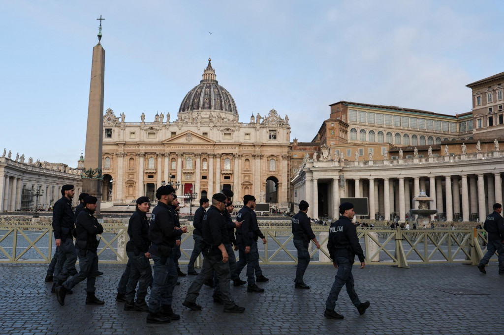 Policajti kráčajú v blízkosti Baziliky svätého Petra pri tom, ako veriaci stoja v rade, aby vzdali úctu pápežovi Františkovi v Ríme. FOTO: Reuters