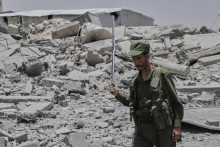 Jemenský vojak si prezerá materiálne škody po leteckom útoku pravdepodobne americkej armády na jemenskú metropolu Saná. FOTO: TASR/AP