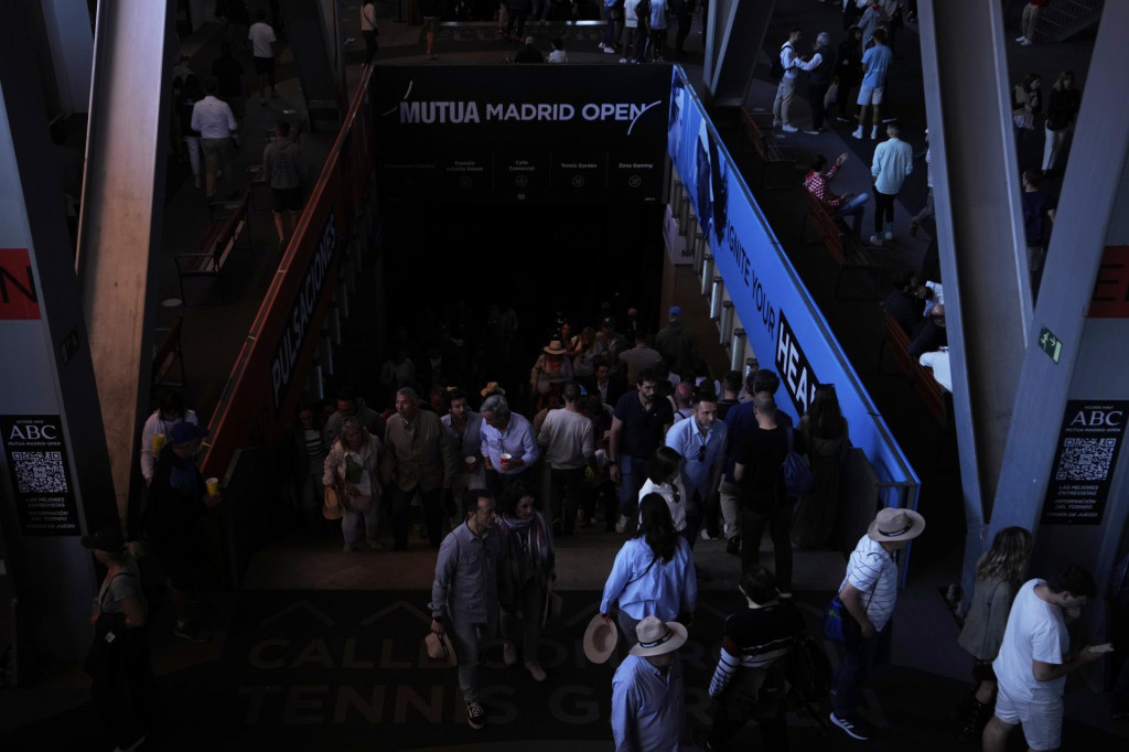 Diváci sa pohybujú v dejisku tenisového turnaja v Madride počas výpadku elektrického prúdu. FOTO: TASR/AP
