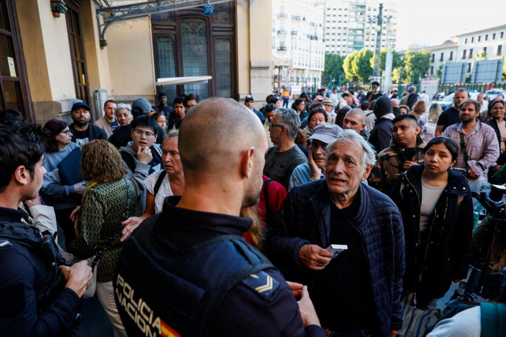 Muž sa pozerá na policajta, keď výpadok prúdu zasiahol veľkú časť Španielska vo Valencii. FOTO: Reuters