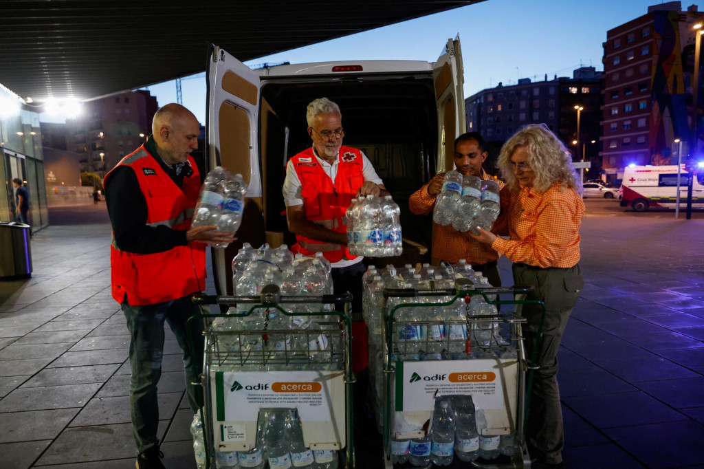 Členovia Červeného kríža nakladajú fľaše s vodou na vozíky neďaleko stanice Joaquin Sorolla vo Valencii, keďže výpadok prúdu zasiahol veľkú časť Španielska. FOTO: Reuters