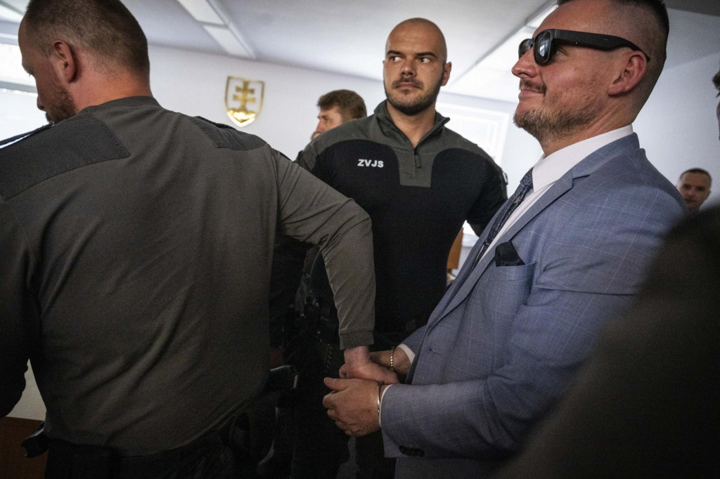Daniel Bombic, obvinený z extrémistickej trestnej činnosti, odchádza s policajnou eskortou po pojednávaní na Najvyššom súde v Bratislave v utorok 29. apríla 2025. 

FOTO: TASR/J. Kotian