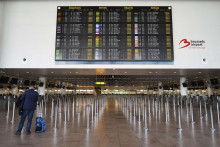 Muž stojí s batožinou pred tabuľou so zrušenými odletmi počas generálneho štrajku na medzinárodnom letisku Zaventem v Bruseli v pondelok. FOTO: TASR/AP

