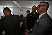 Na snímke Daniel Bombic, obvinený z extrémistickej trestnej činnosti, odchádza s policajnou eskortou po pojednávaní na Najvyššom súde v Bratislave. FOTO: TASR/Jakub Kotian