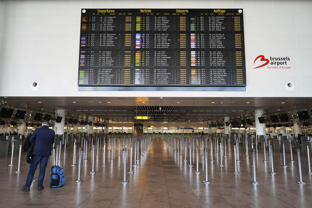 Muž stojí s batožinou pred tabuľou so zrušenými odletmi počas generálneho štrajku na medzinárodnom letisku Zaventem v Bruseli v pondelok. FOTO: TASR/AP
