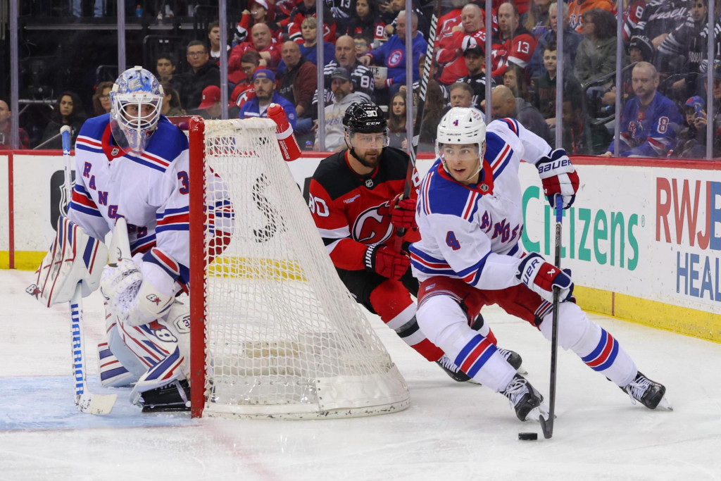 Obranca New York Rangers Braden Schneider (4) korčuľuje s pukom, zatiaľ čo ľavé krídlo New Jersey Devils Tomáš Tatar (90) bráni počas druhej tretiny v Prudential Center. FOTO: Ed Mulholland