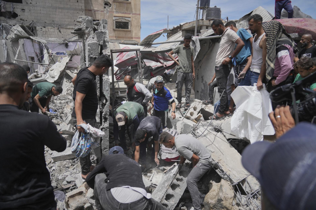 Palestínčania prehľadávajú ruiny domu, ktorý sa stal terčom útoku izraelskej armády, pri ktorom zahynulo najmenej päť členov rodiny, v meste Chán Júnis, na juhu Pásma Gazy. FOTO: TASR/AP