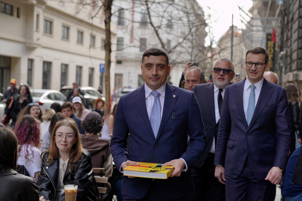 Na snímke líder druhej najväčšej rumunskej strany Aliancie zjednotených Rumunov George Simion a bývalý poľský premiér Mateusz Morawiecki kráčajú po ulici po tom, čo Simion predložil svoju kandidatúru na prezidentské voľby v Bukurešti. FOTO: Reuters