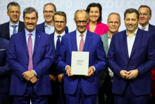 Nastupujúci nemecký kancelár a líder Kresťanskodemokratickej únie Friedrich Merz drží koaličnú vládnu dohodu medzi CDU/CSU a SPD. FOTO: Reuters
