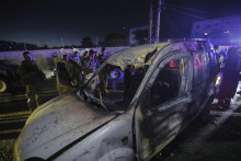Záchranári a vojaci prezerajú vrak auta po dronovom útoku izraelskej armády na prístavné mesto Sidon na juhu Libanonu. FOTO: TASR/AP
