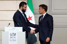 Francúzsky prezident Emmanuel Macron si podáva ruku so sýrskym prezidentom Ahmadom Šarom. FOTO: Reuters